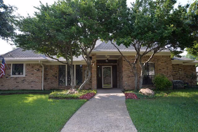 Entrance to Silver Leaf Assisted Living & Memory Care; brick building with trees.