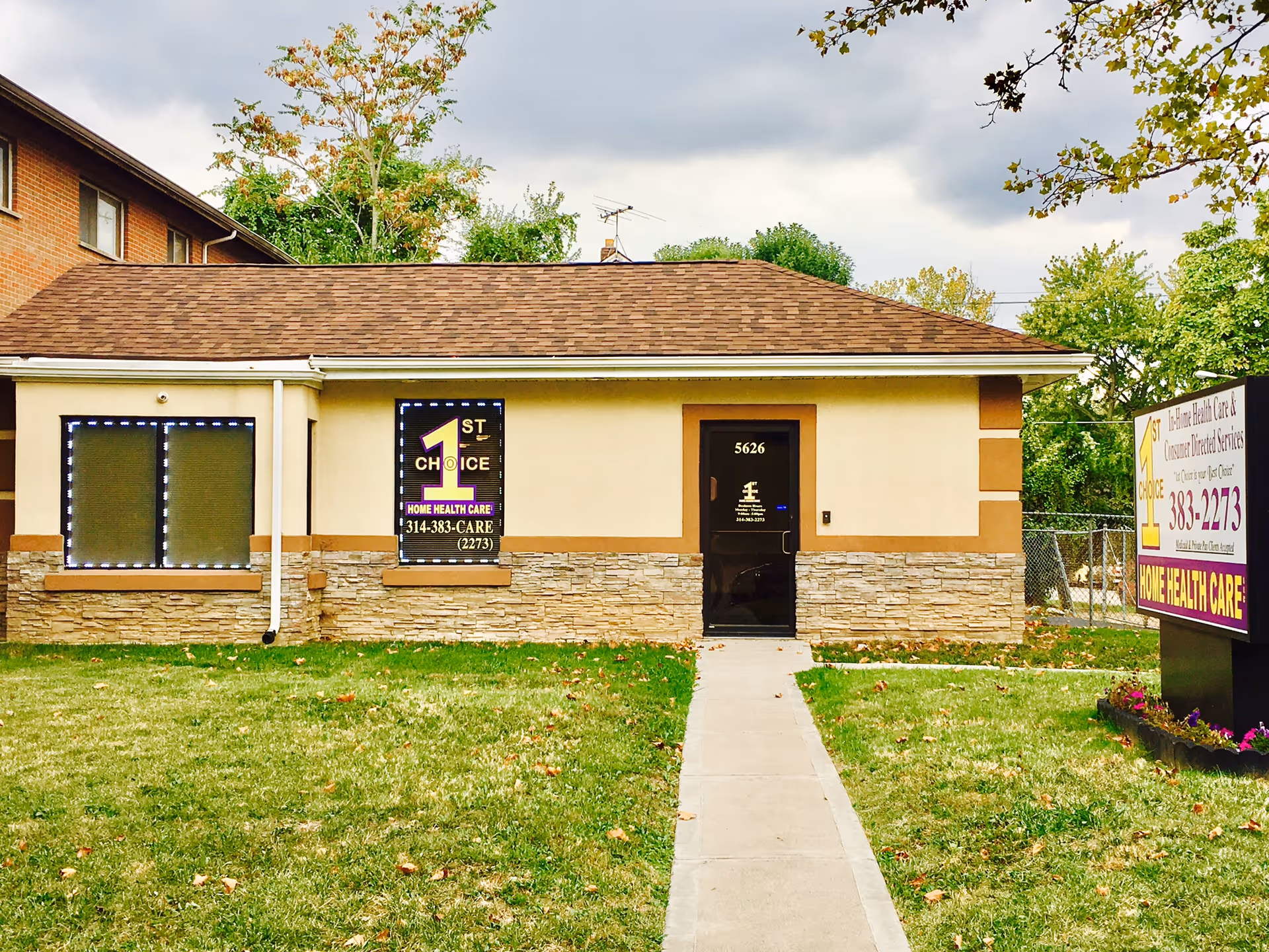 Single-story beige building with front door, walkway, and signs for 1st Choice Home Health Care.