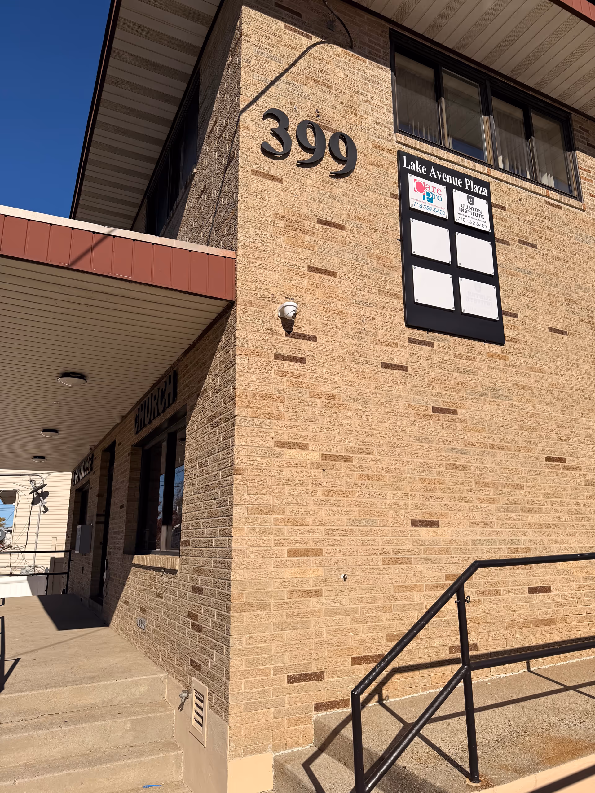 Exterior view of a brick senior facility at 399 with a Lake Avenue Plaza sign.