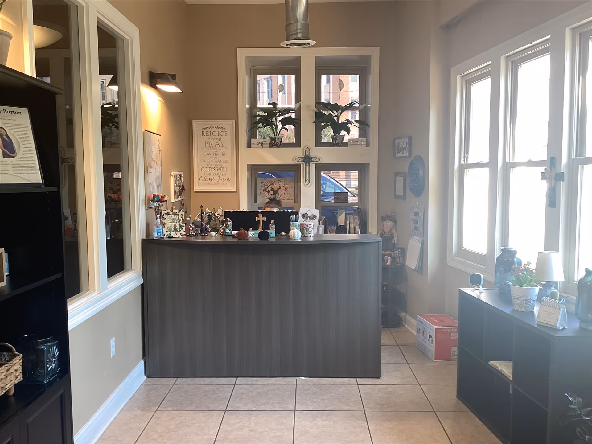 Lobby reception desk inside a senior living facility with windows, plants, and decor.