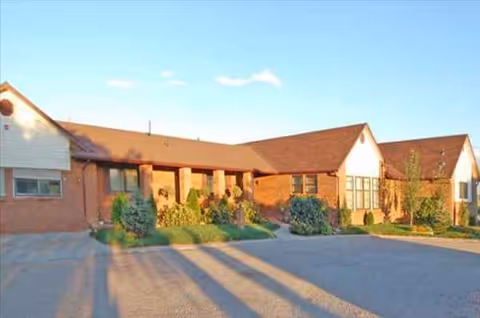 Brick exterior of a senior living facility with landscaped entrance.