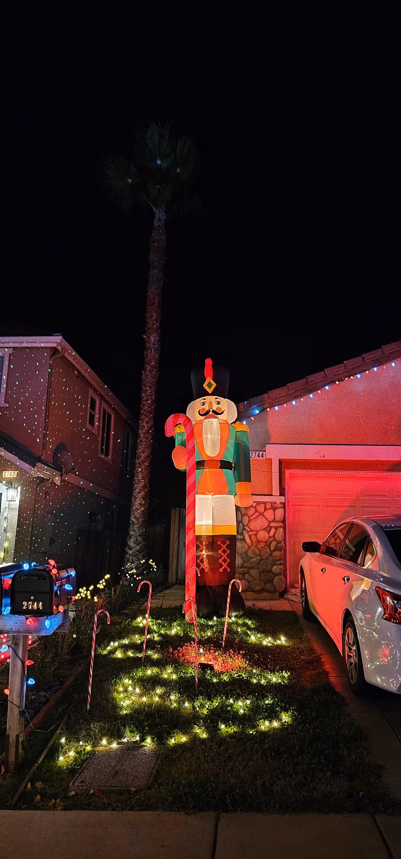 Night exterior of a senior living facility with a large illuminated nutcracker display.