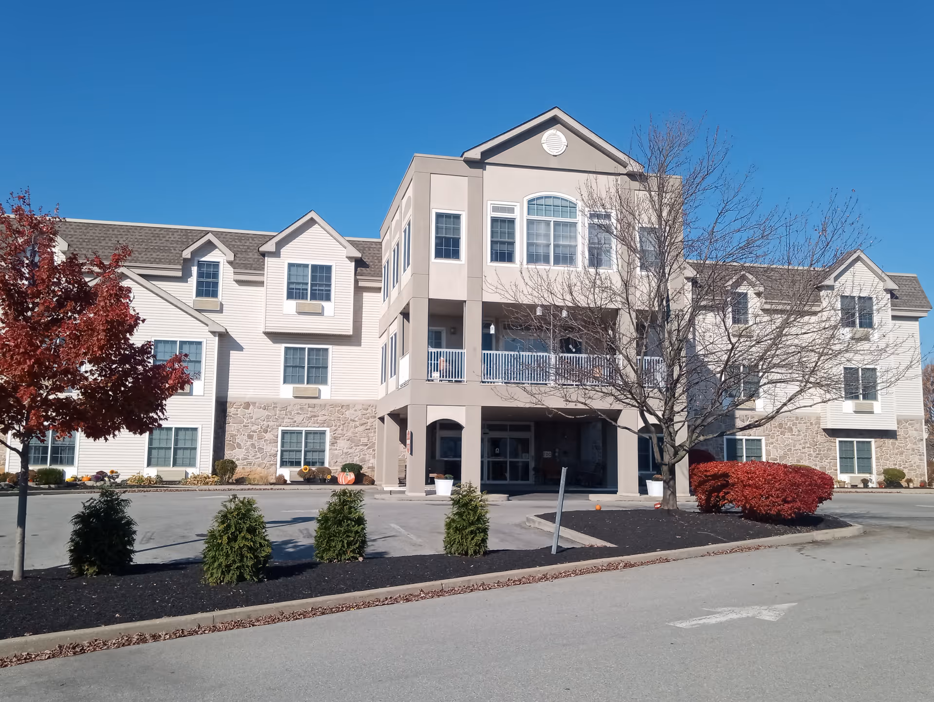 Exterior view of The Willow senior living facility with entrance and landscaping