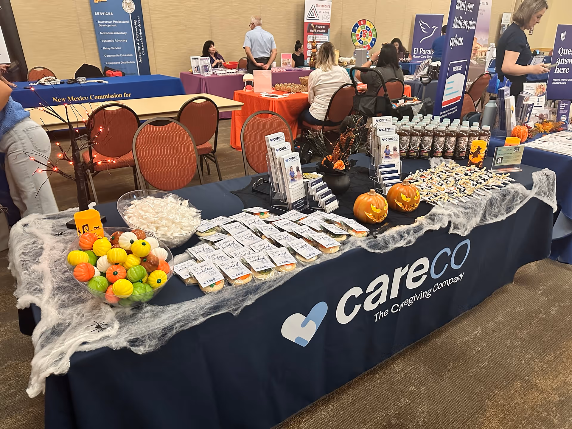 Promotional CareCo table at an indoor senior care expo with brochures.