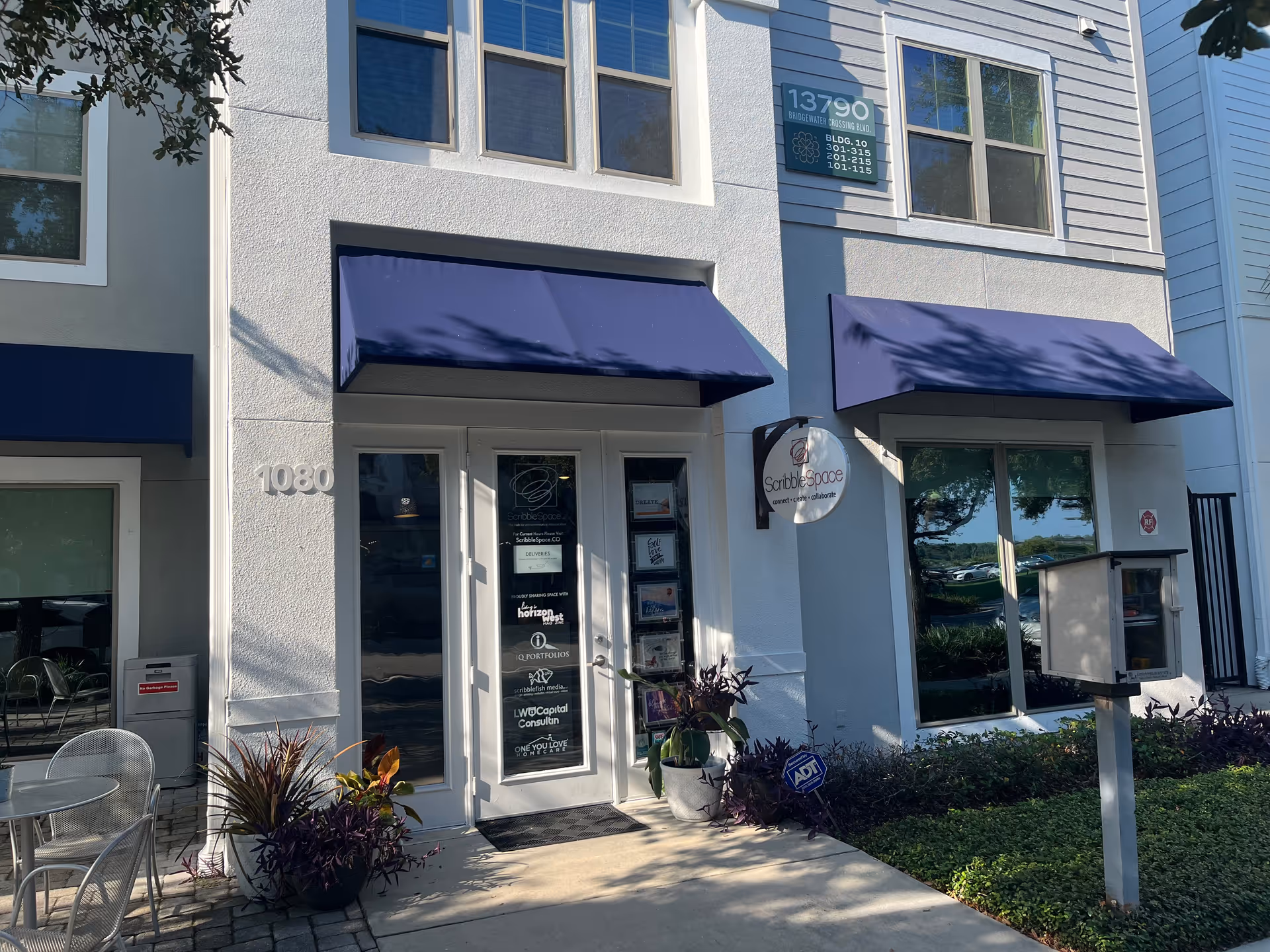 Exterior storefront of a senior care facility with blue awnings and glass doors.