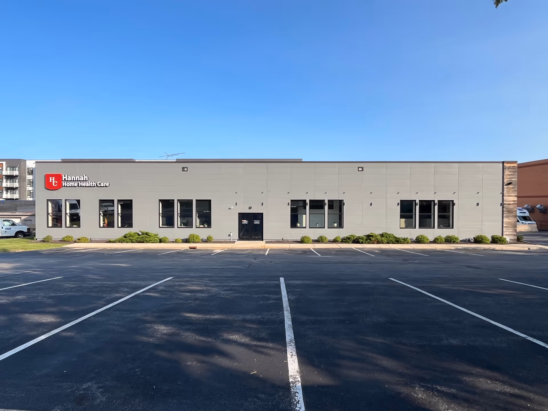 Hannah Home Health Care building with parking lot and clear blue sky.