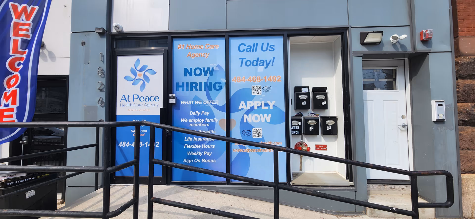 Front exterior of At Peace Home Care Agency with blue hiring signs and a ramp.