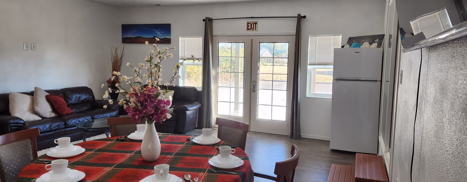 Dining table with plates, cups, and a flower centerpiece in a senior home living area.