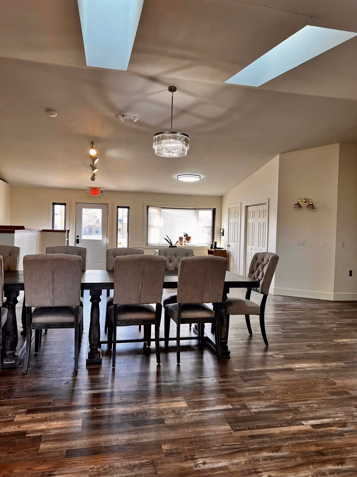 Lincoln Lane Assisted Living dining room with long dark wood table and beige chairs.