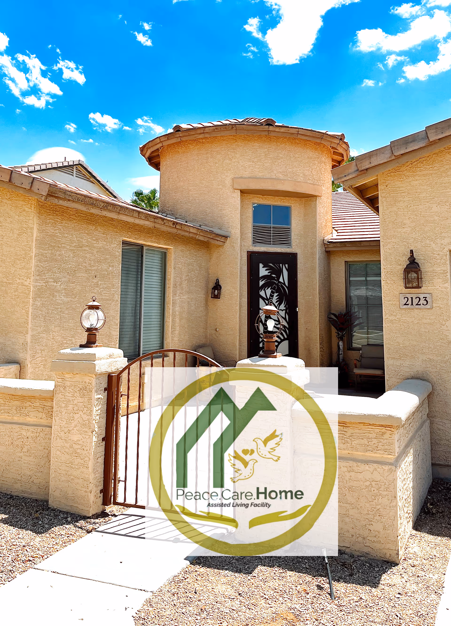 Exterior view of Peace Care Home entrance with beige stucco building and gate.