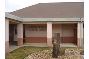 Front entrance of Garden Oasis Assisted Living with a sign and landscaped rock feature.