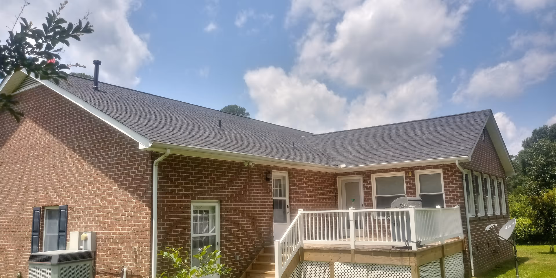 Single-story brick senior living facility exterior with a raised wooden deck and stairs.