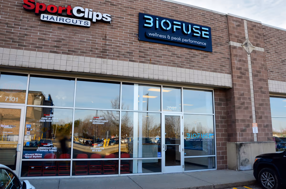 Exterior view of Biofuse wellness storefront with large glass windows and Sport Clips sign.