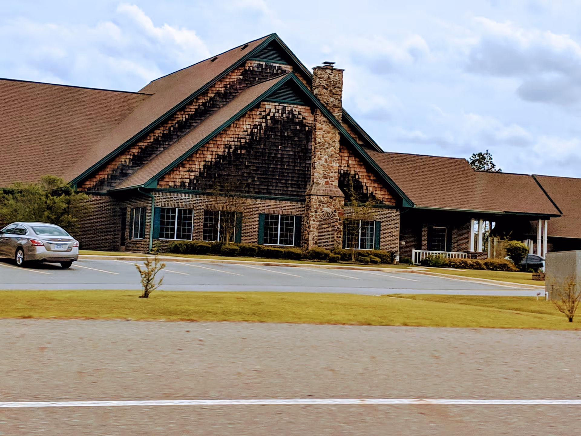 Exterior view of Life Touch Hospice building with brick walls and sloped roof.