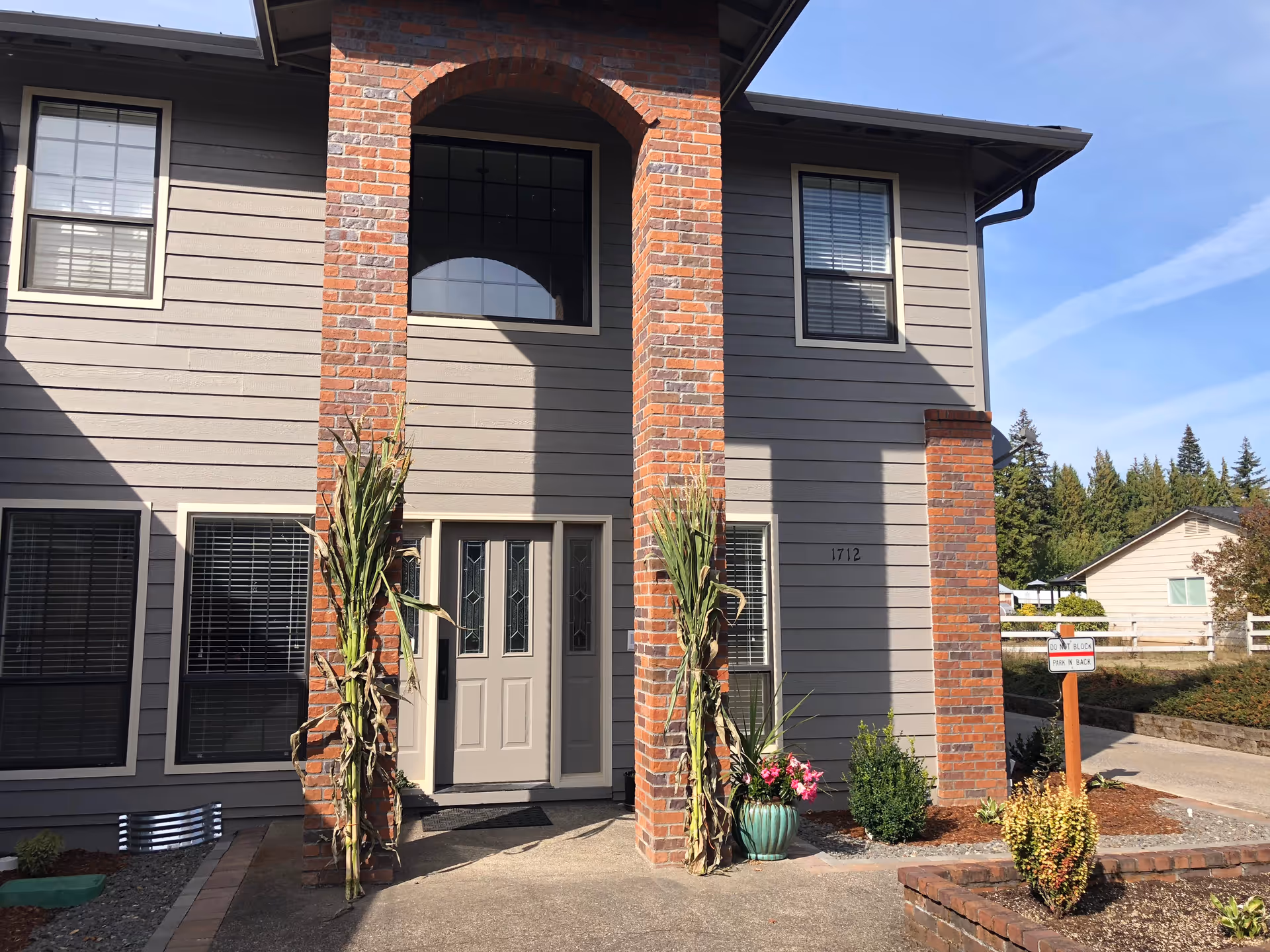 Exterior of Dayspring Memory Care building with brick columns, a double entry door, and potted plants.