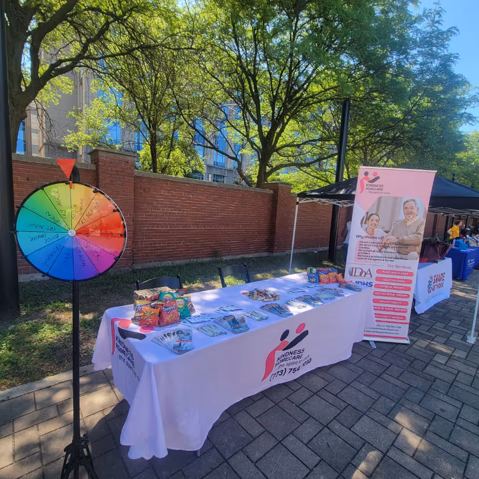 Outdoor information booth with a long table, banners, and a colorful spin wheel.
