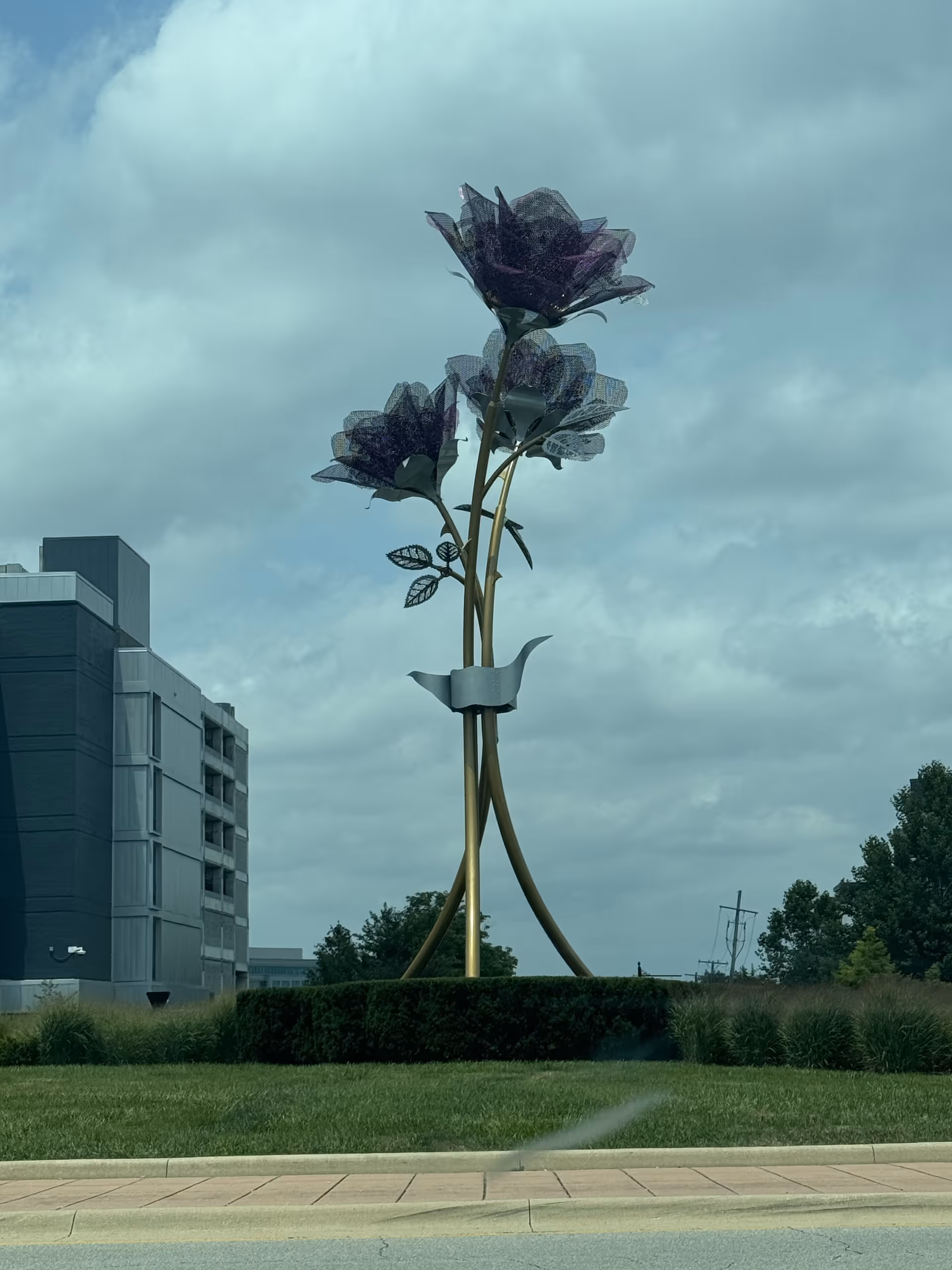 Exterior view of Wellbrooke of Carmel with a tall decorative flower sculpture.