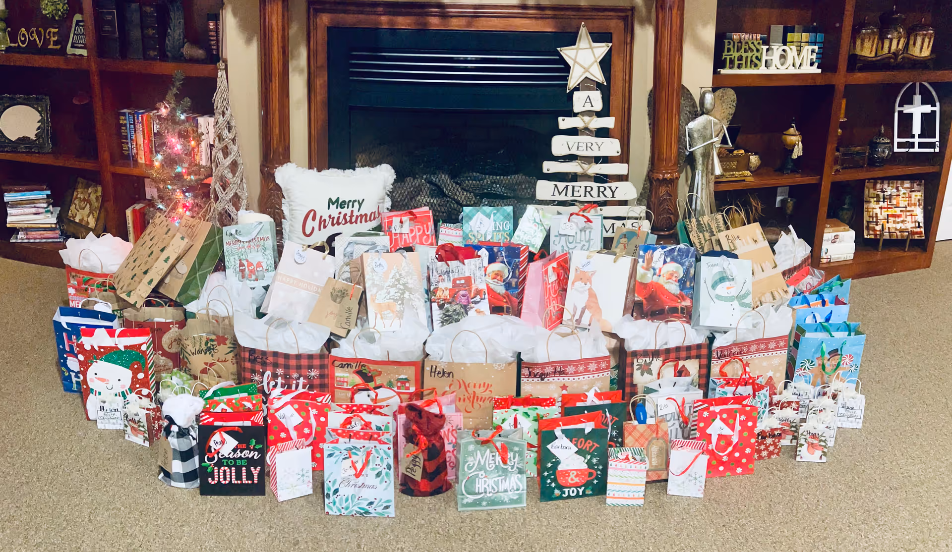 A living room with a fireplace and shelves, surrounded by many wrapped gift bags.