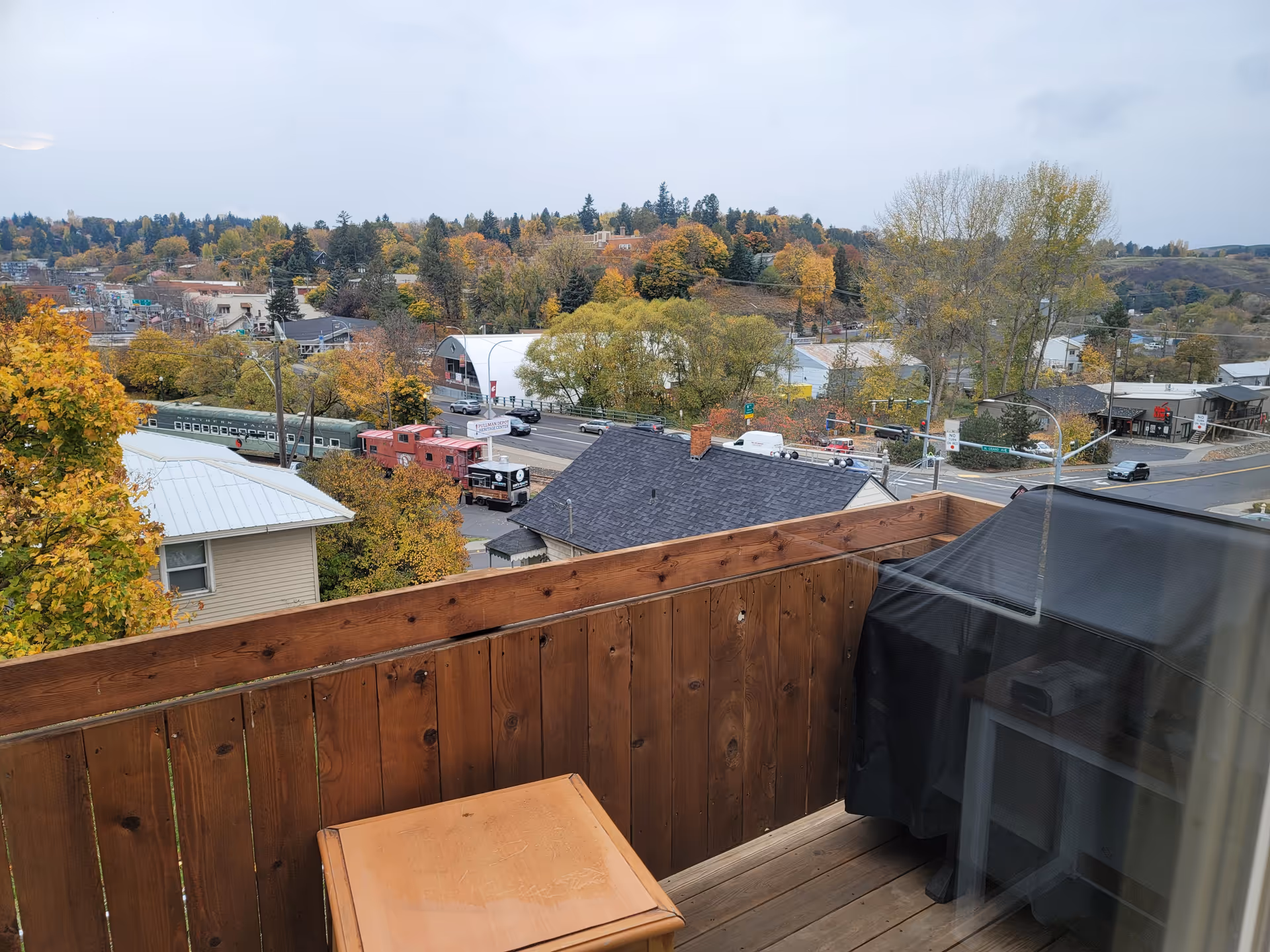 Balcony view of autumn trees and a street scene from a residence.