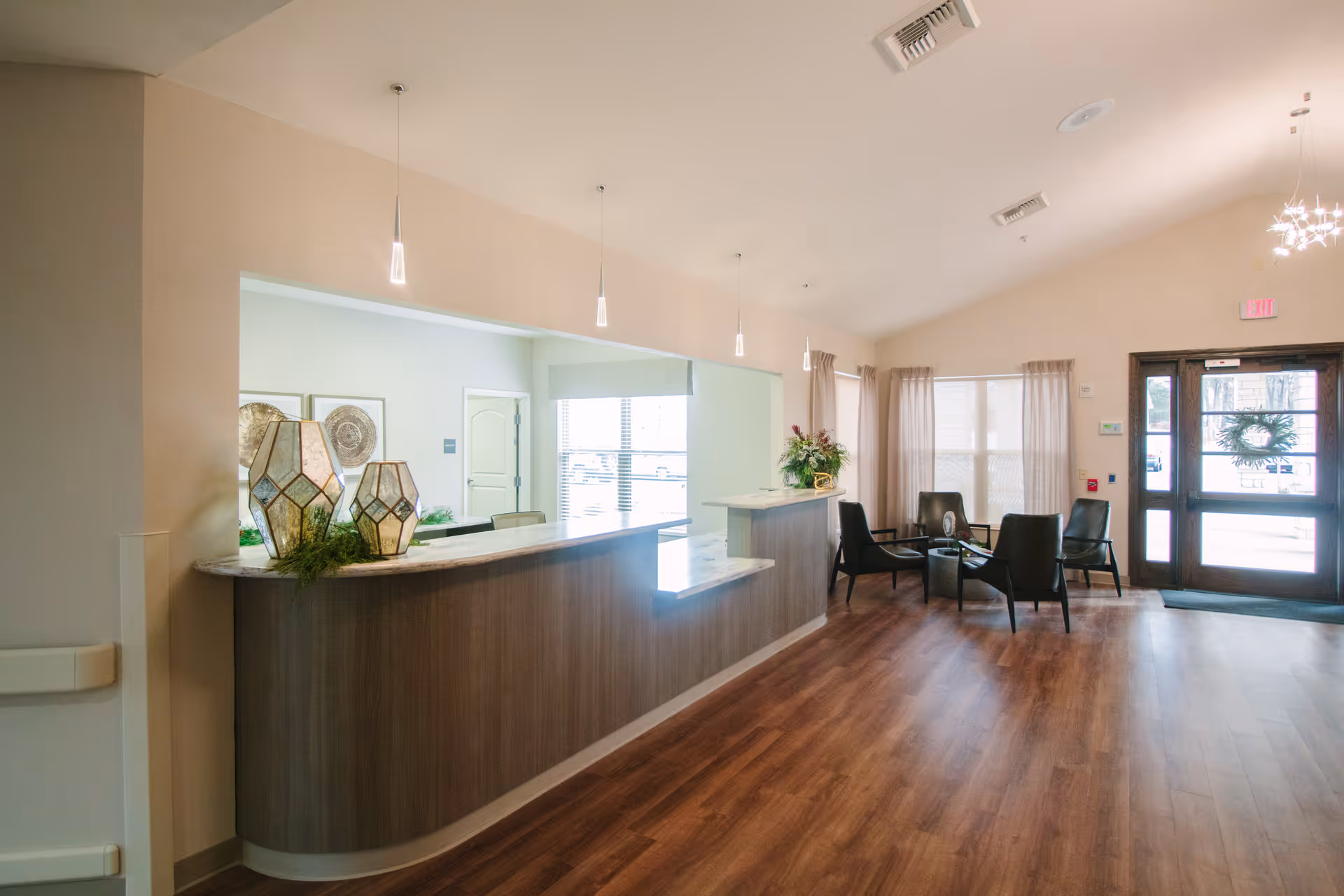 A modern reception desk in a spacious senior living lobby with seating area.