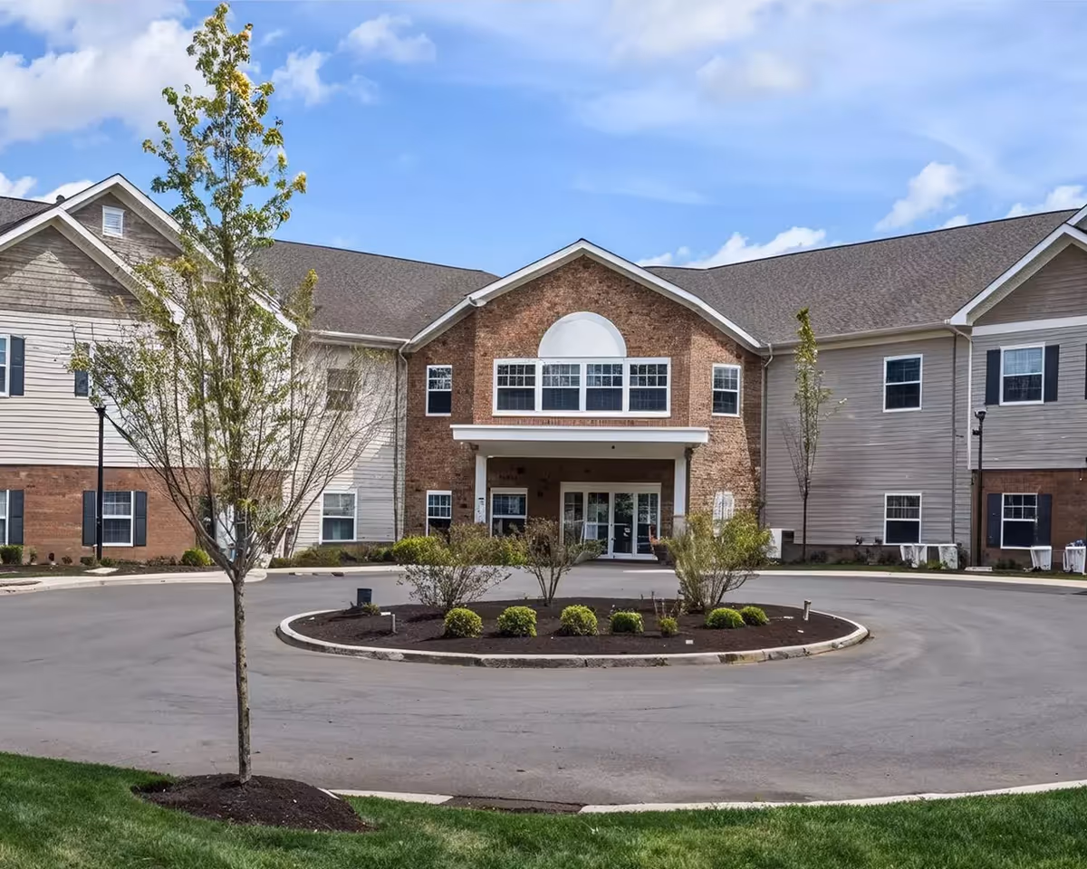 Exterior view of a Danbury Wooster senior living building with circular driveway and landscaping.