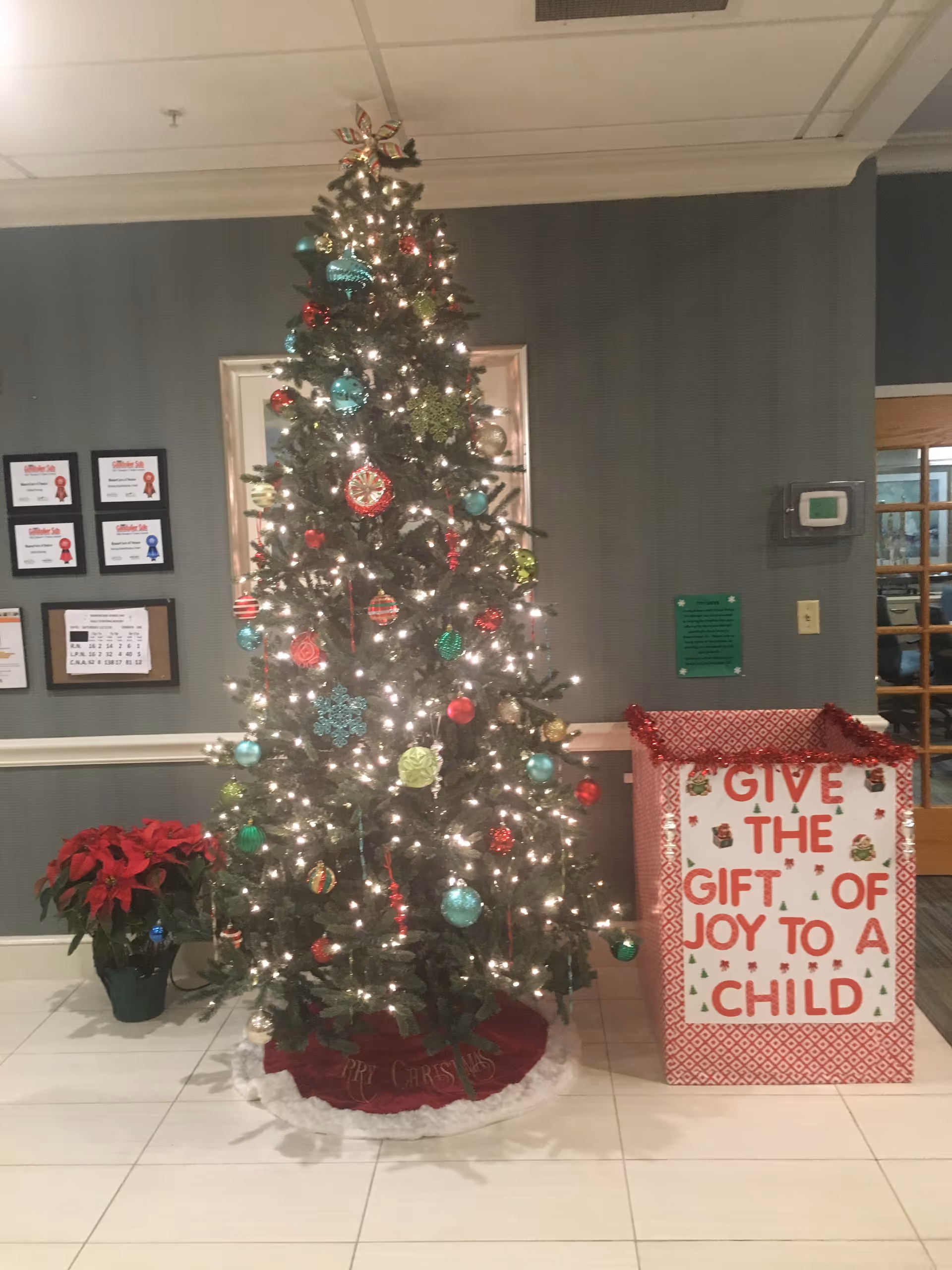 Decorated Christmas tree with lights and ornaments stands in a ManorCare Venice lobby.