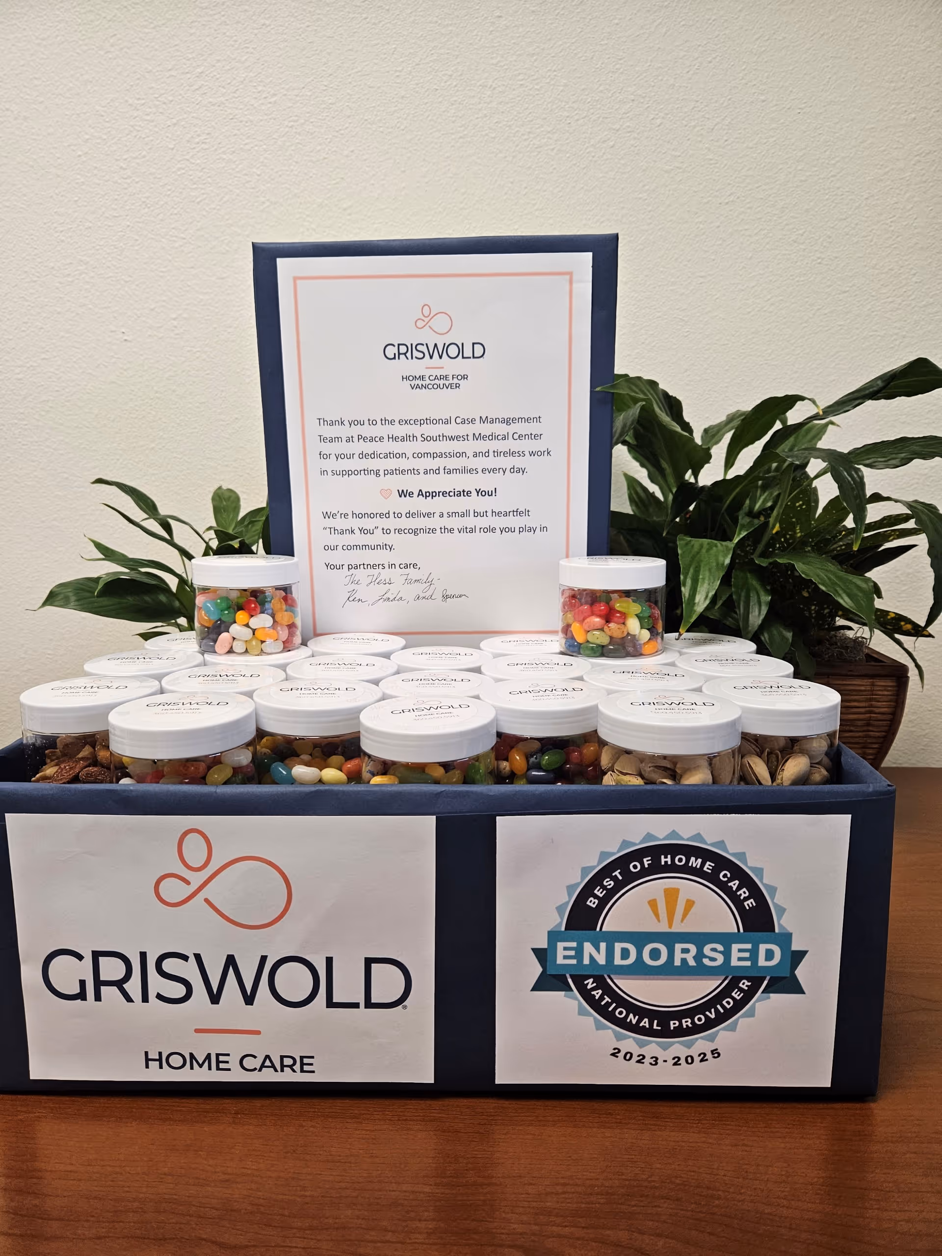 Display of candy jars and signs on a blue counter inside a Griswold Home Care facility.