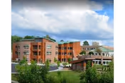 Exterior view of The Community at Rockhill, a brick senior living building with landscaped grounds.