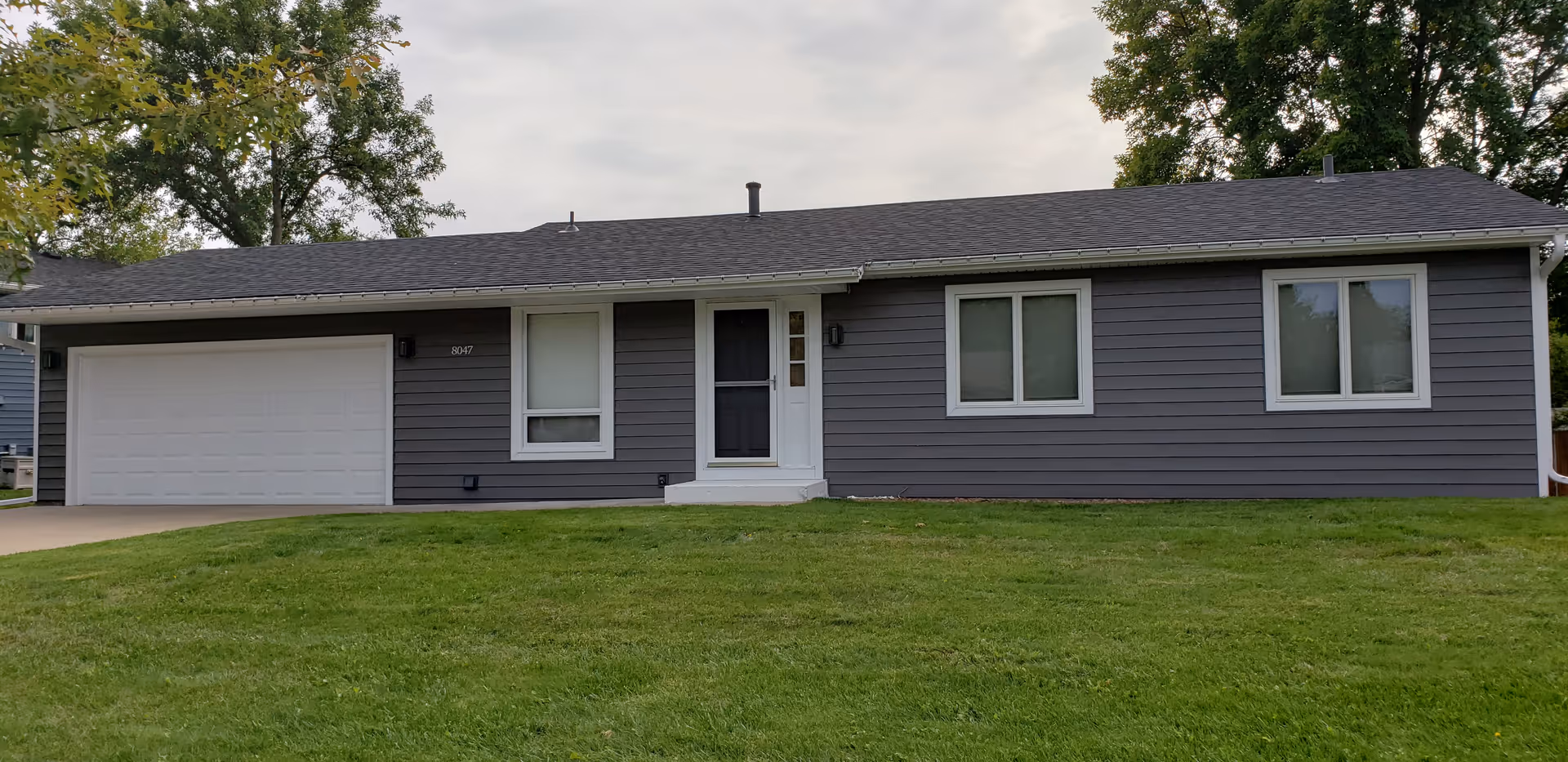 Front view of Highland Homes and Services, Inc., a single-story gray building with a two-car garage.