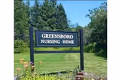 Greensboro Nursing Home sign on a grassy lawn with trees.