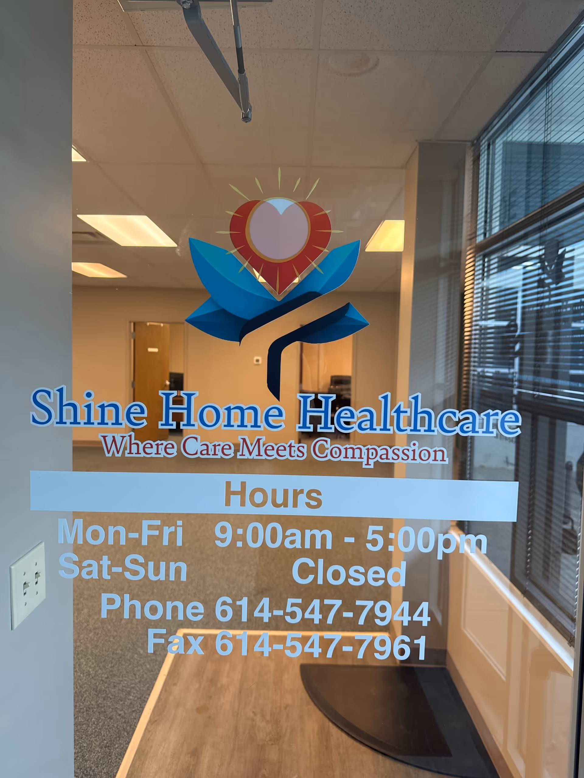 Glass door displays Shine Home Healthcare logo and hours inside a hallway reception area.