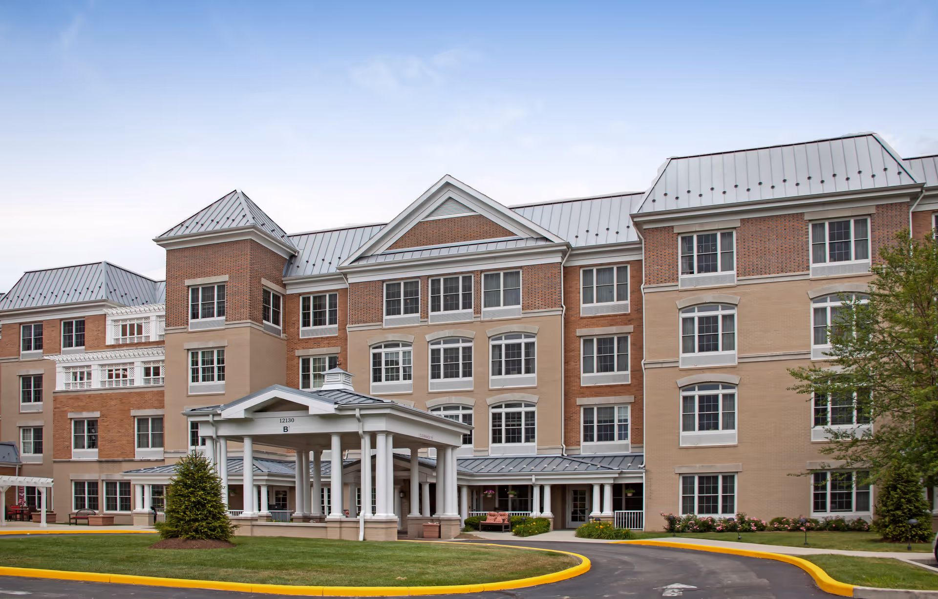 Exterior view of a Sunrise on Old Meridian senior living facility with a circular driveway.