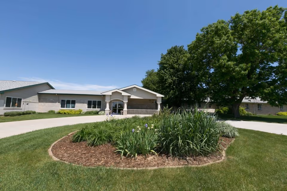 Front view of West Bend Health and Rehabilitation with landscaped circular garden and driveway.