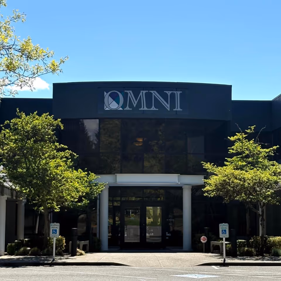 Front view of a modern building with glass entrance and trees