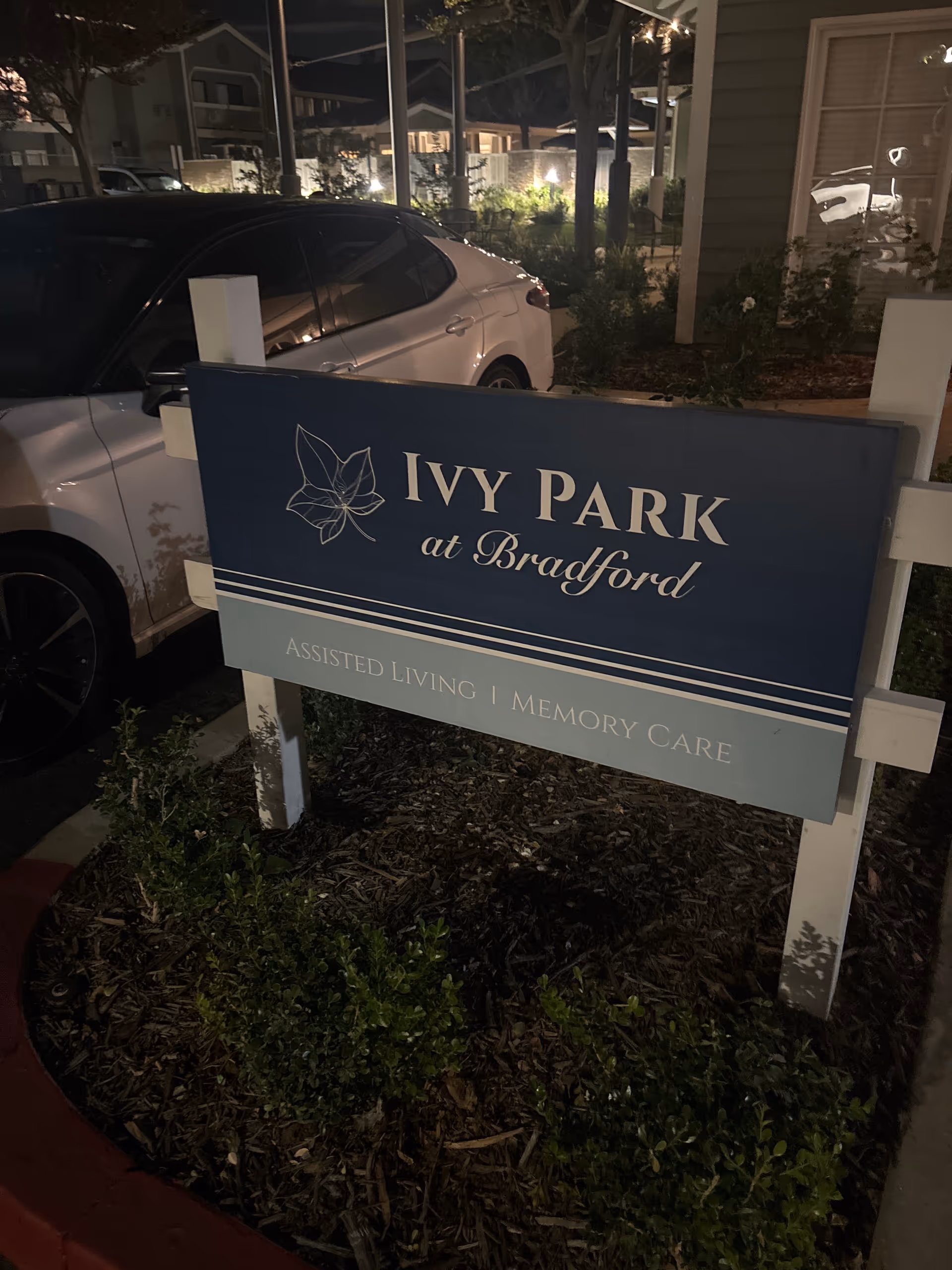Exterior view of Ivy Park at Bradford sign in front of building at night.
