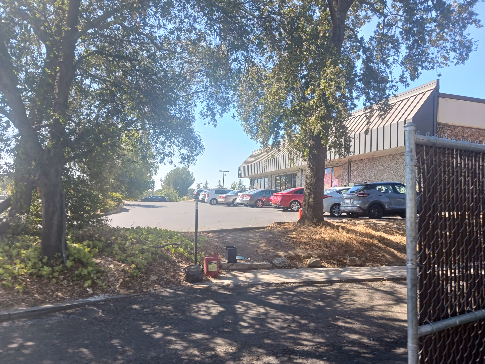 Exterior view of RiverPointe Post Acute with parked cars and trees.