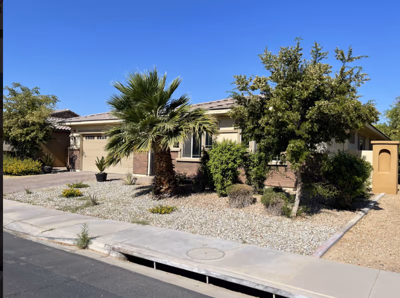 Front exterior of Destiny Care Home, a single-story house with desert landscaping and palm trees.
