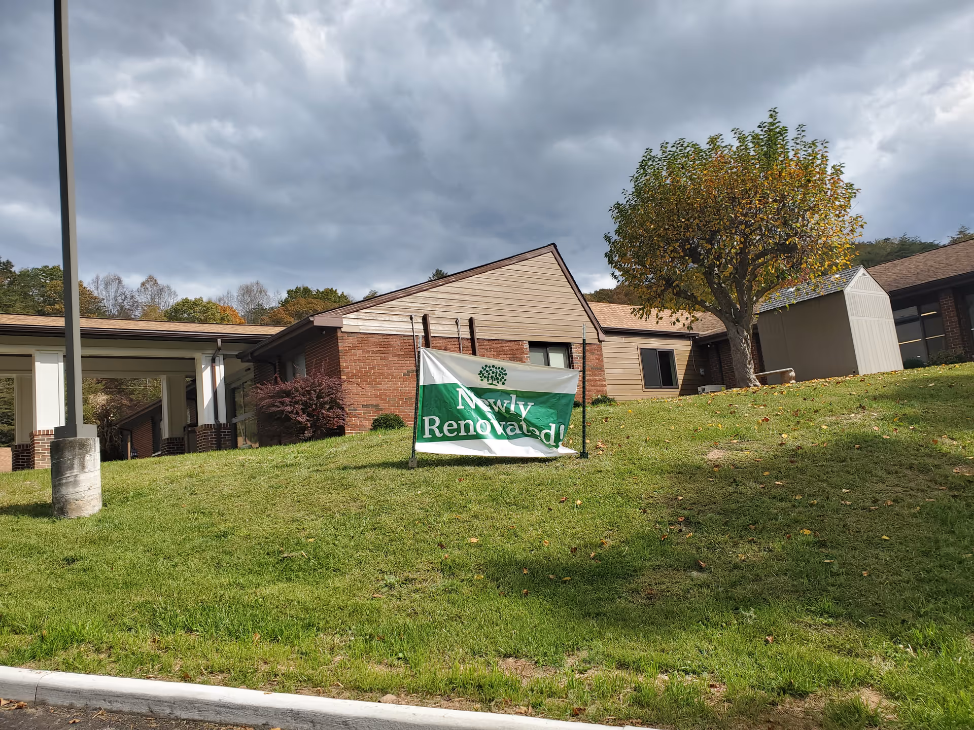 Exterior view of Summers Healthcare Center with a Newly Renovated banner on a grassy slope.