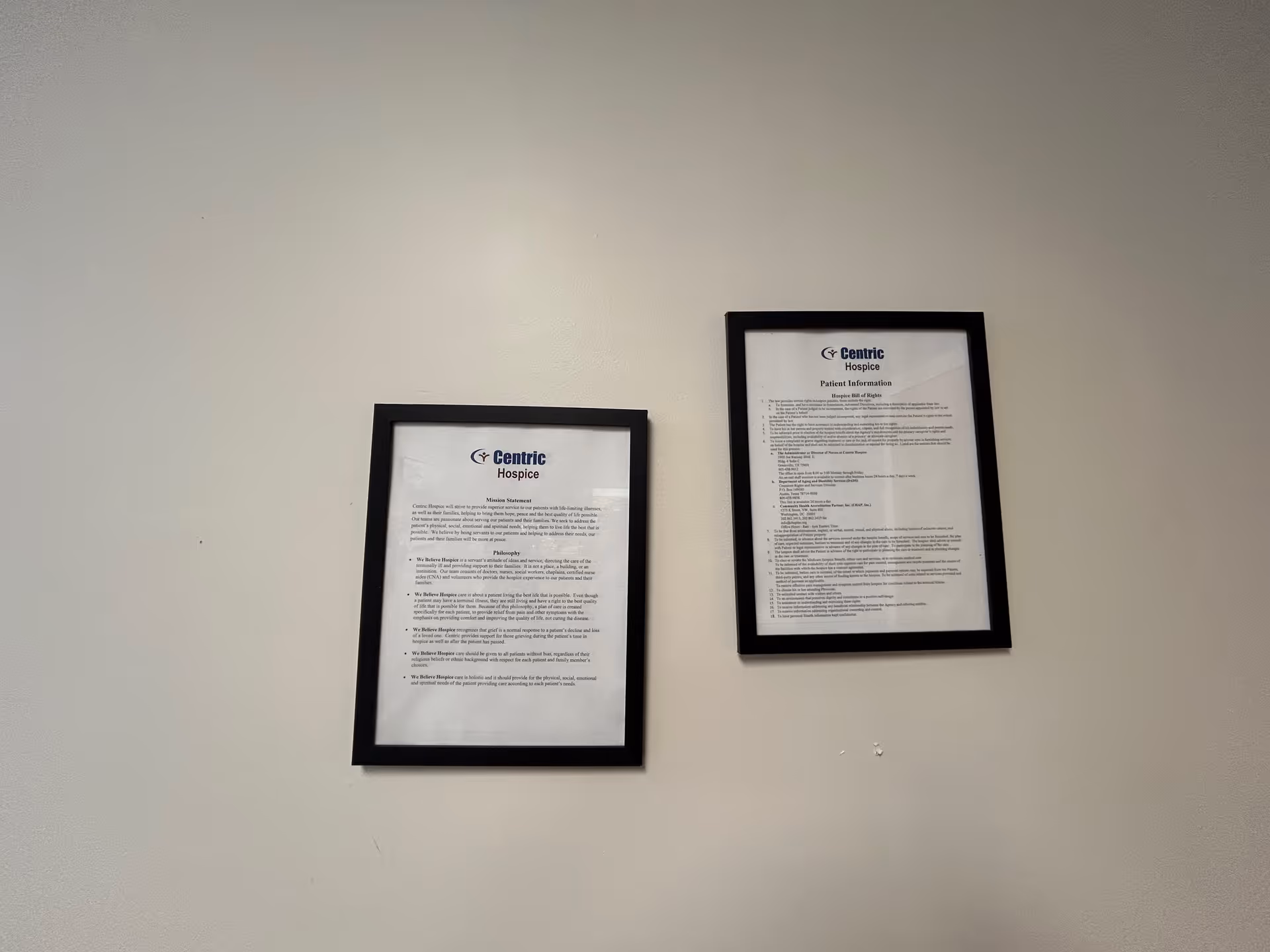 Two framed documents on a light wall, with Centric Hospice logos.