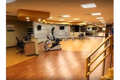 Interior fitness area at Baldwin Health Center with exercise equipment and a reception desk.