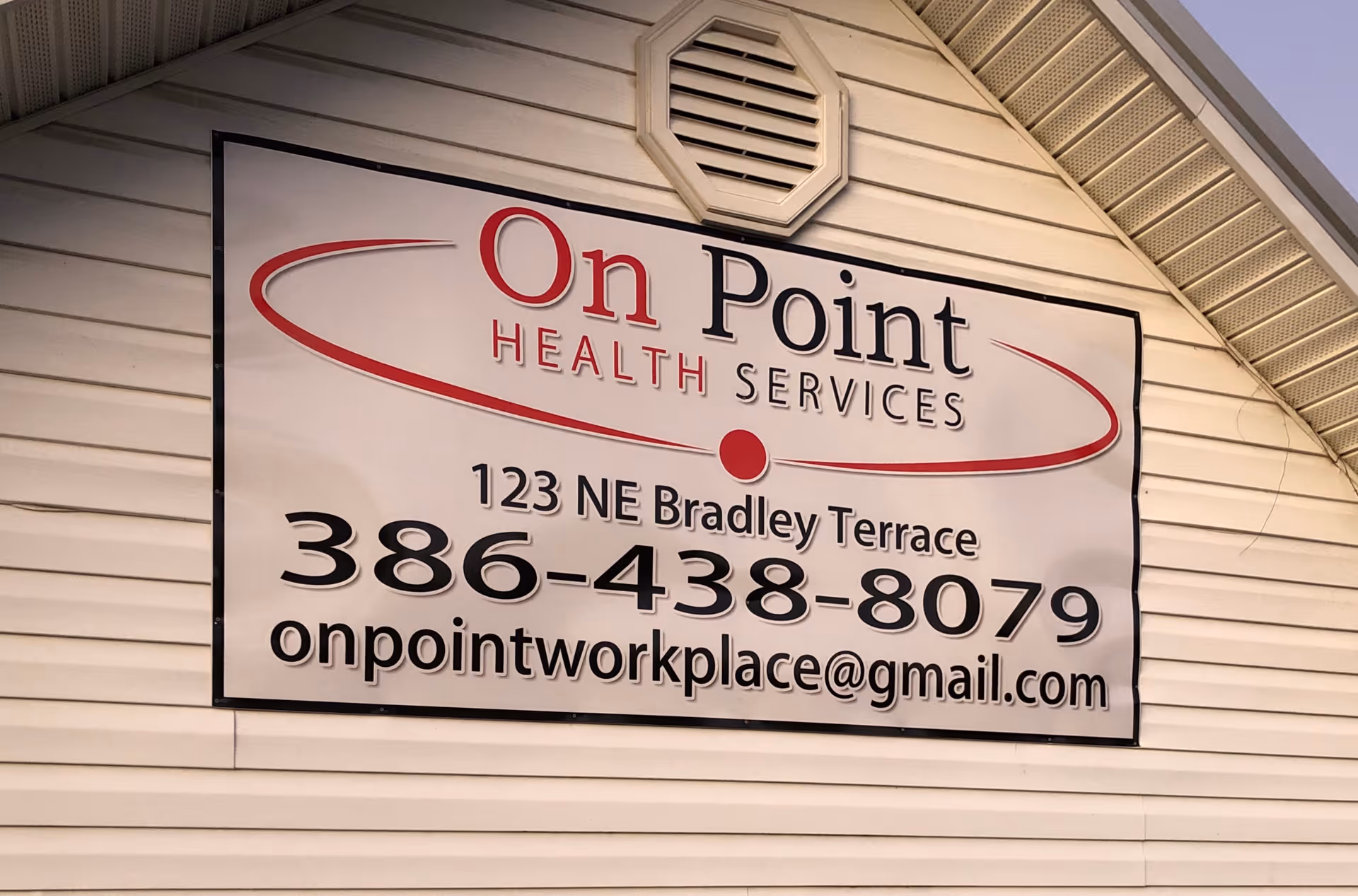 Exterior wall with a large sign reading On Point Health Services and contact information.
