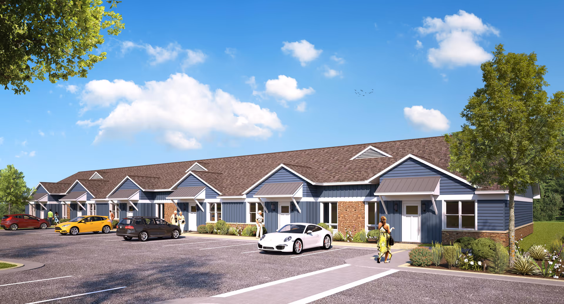Exterior view of English Meadows Harrisonburg Campus; blue siding buildings, brick accents, and parked cars.