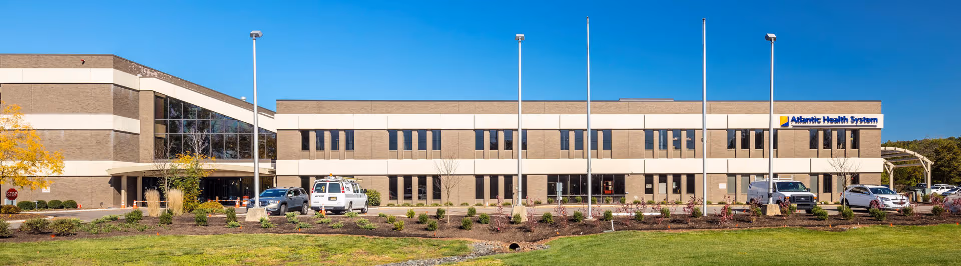 Front view of a two-story Atlantic Health System Bridgewater Pavilion building with parking lot.