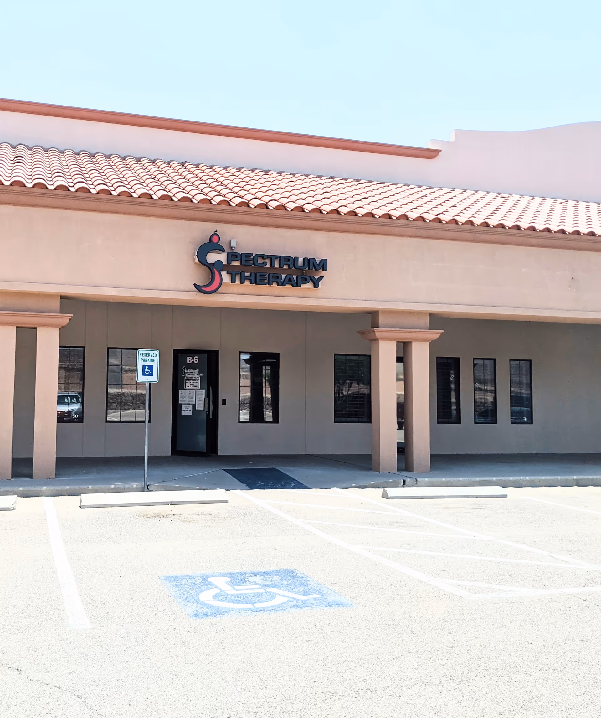Front view of Spectrum Therapy facility with covered entrance and handicap parking.