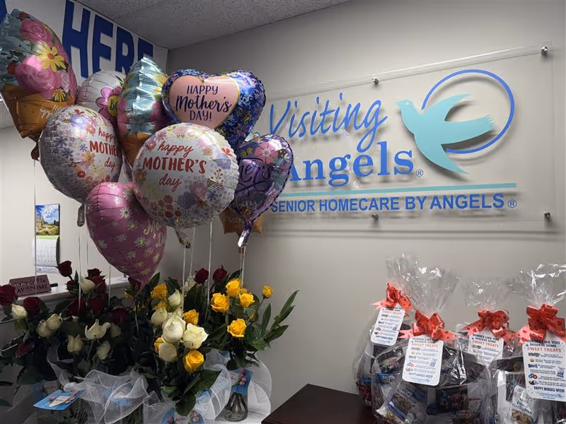 Reception area featuring balloons, flowers, and a Visiting Angels sign.