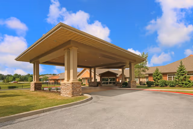 Covered entrance with large pillars guides drivers to Life Care Center of Florissant.