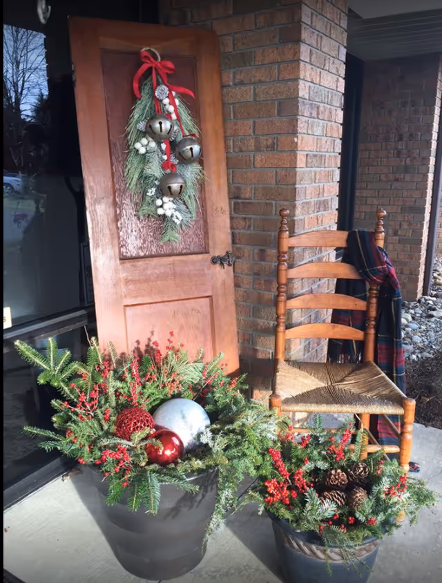 Norton Guest Home entrance with wreath, wooden chair, and festive potted plants.