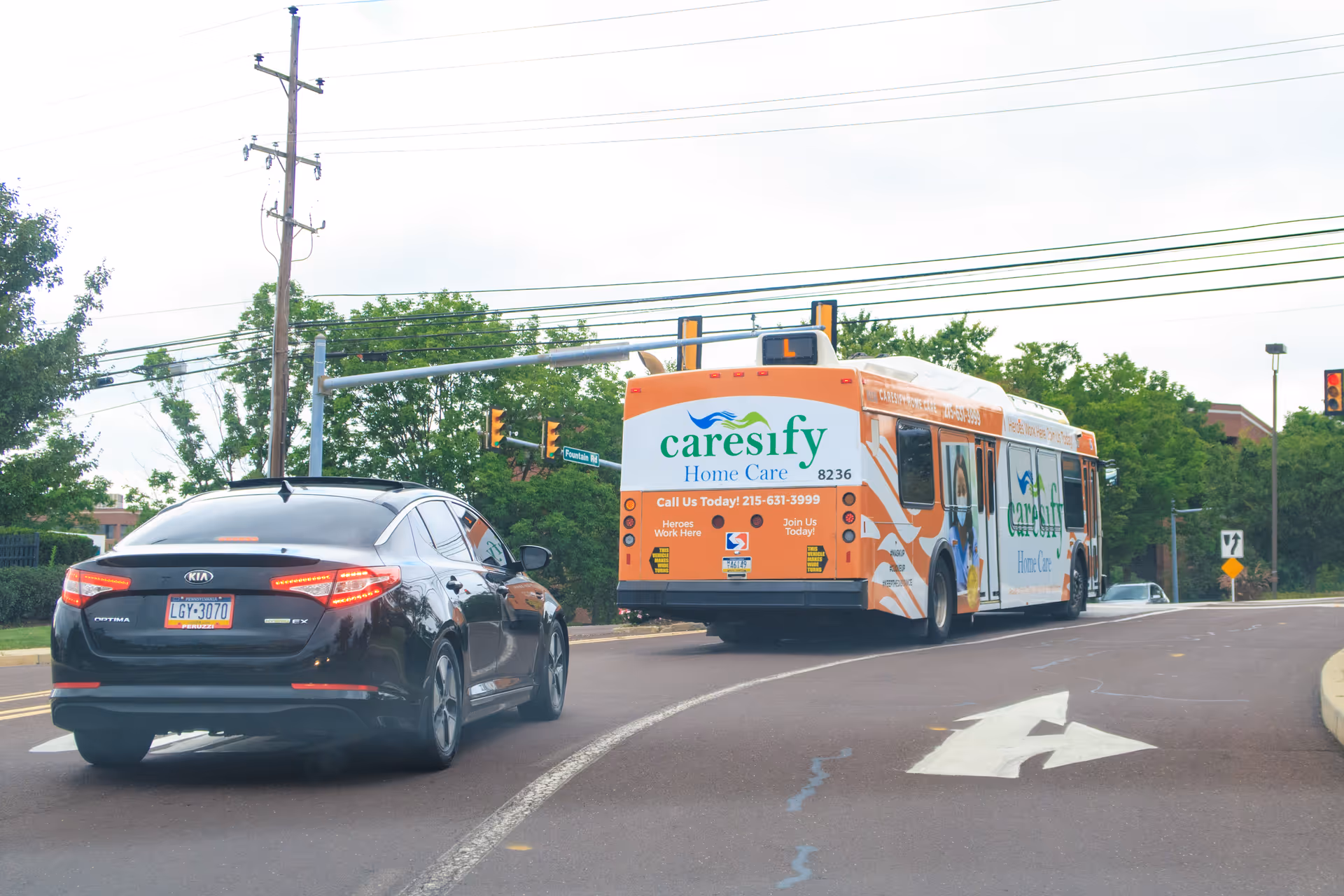 Caresify Home Care Orlando orange bus drives down a street beside a black car.