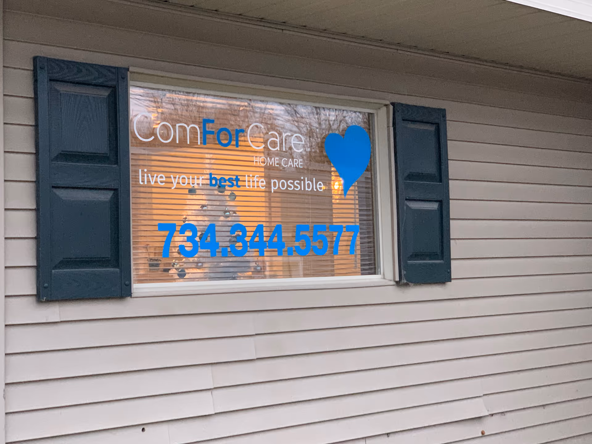 Exterior wall with a window sign for ComForCare Home Care and a blue heart logo