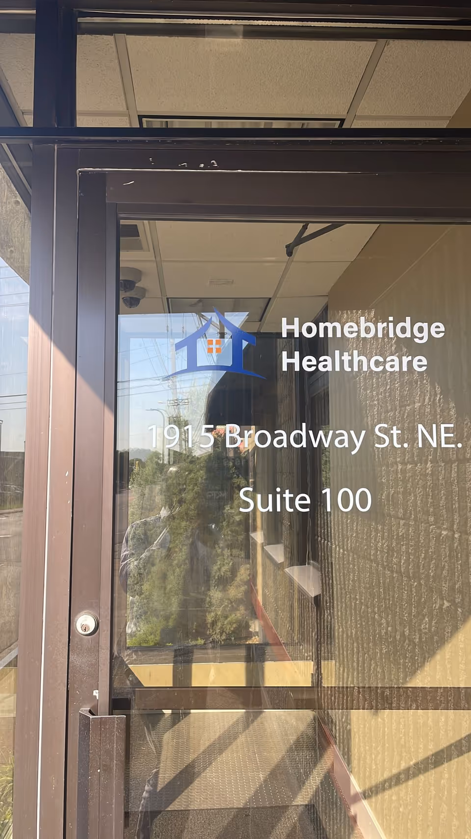 Glass entrance door shows Homebridge Healthcare logo and address on the building front.